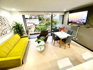 sala de estar con sofá amarillo y mesa en Apartamento en unidad con Full Entretenimiento, en Medellín