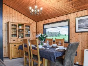a dining room with a table and chairs and a window at Glendowlin Lodge Retreat in Tirril