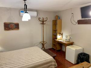 a bedroom with a bed and a desk in it at Departamento 16 en el centro Tafi del Valle in Tafí del Valle