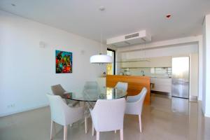 une salle à manger avec une table en verre et des chaises blanches dans l'établissement Deluxe Villa Jante Infinity Pool, à Durrës