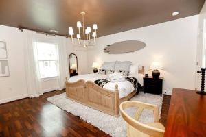 um quarto com uma cama grande e um lustre em Bayside Bungalow em Norfolk