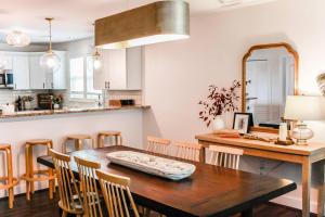 uma cozinha e sala de jantar com uma mesa de madeira e cadeiras em Bayside Bungalow em Norfolk