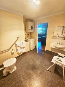 a bathroom with a toilet and a sink at Emerald Motel Apartments in Emerald
