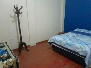 1 dormitorio con cama y espejo. en Acogedor apartamento en Píllaro, en Píllaro