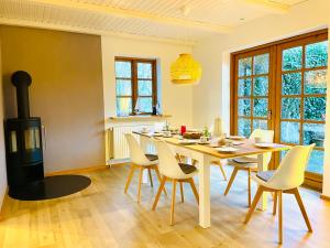 a dining room with a table and a wood stove at Schleikate Ekenis in Ekenis