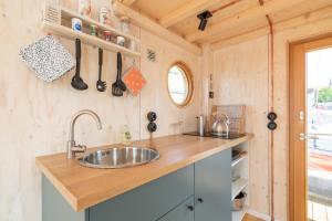 a kitchen with a sink in a tiny house at Hausboot Helena in Schleswig