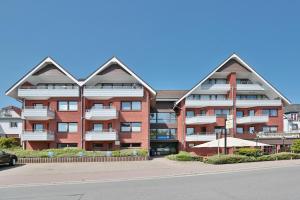 un gran edificio de ladrillo rojo con dos techos puntiagudos en Seeburg Appartement 26, en Scharbeutz