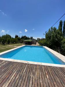 une grande piscine bleue sur une terrasse en bois dans l'établissement Cabañas Vista Andes VI, à Luján de Cuyo