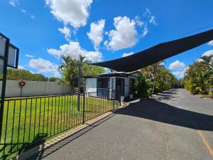 a gate in front of a house with a fence at Emerald Motel Apartments in Emerald