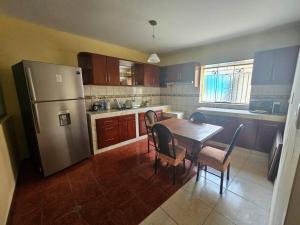 cocina con mesa, sillas y nevera en Casa familiar en Arequipa en Arequipa
