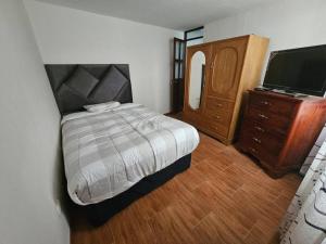 1 dormitorio con 1 cama, vestidor y TV en Casa familiar en Arequipa en Arequipa