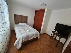 - une chambre avec un lit et une télévision à écran plat dans l'établissement Casa familiar en Arequipa, à Arequipa