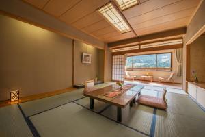 a living room with a table and a large window at Yamagataya in Gero