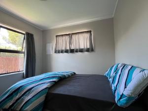 a bed in a room with a window at Stay with Benny in Nelson