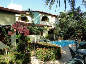 a house with a swimming pool and some flowers at Hotel Pousada Arco Iris in Barra de Santo Antônio