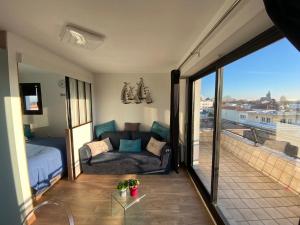 salon z kanapą i balkonem w obiekcie Appartement Royan, 1 pièce, 2 personnes - FR-1-539-31 w mieście Royan