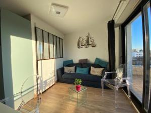 salon z niebieską kanapą i krzesłami w obiekcie Appartement Royan, 1 pièce, 2 personnes - FR-1-539-31 w mieście Royan