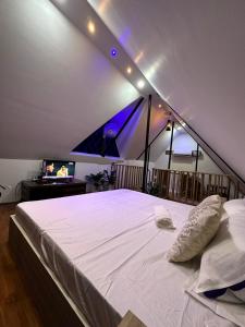 ein Schlafzimmer mit einem großen weißen Bett und einem TV in der Unterkunft Lakeland Homestay Diphu 