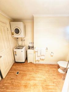 a bathroom with a toilet and a washer and dryer at Emerald Motel Apartments in Emerald