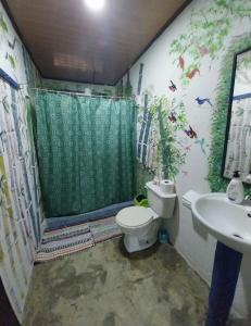 a bathroom with a shower and a toilet and a sink at Happy Monkeys in Puerto Jiménez