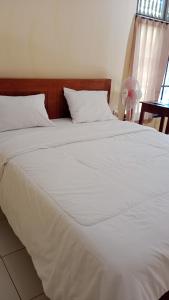 a large white bed with white sheets and pillows at Hause market in Sidemen