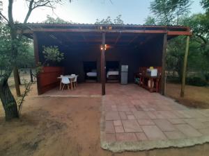 a pavilion with a table and chairs in a field at VlakkiesKraal Bosbok Camp in Bela-Bela