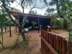 a shed with a table and a fence at VlakkiesKraal Bosbok Camp in Bela-Bela