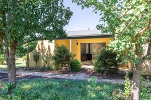 a yellow house with trees in front of it at La Casa in Myrtleford