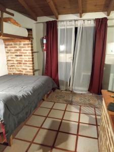 1 dormitorio con 1 cama y cortinas rojas en June en el Uritorco en Capilla del Monte