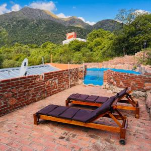un patio con una silla, una mesa y una piscina en June en el Uritorco en Capilla del Monte