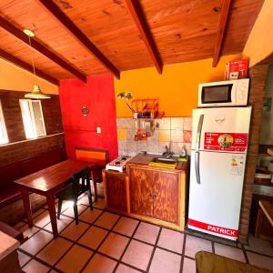 a kitchen with a white refrigerator and a table at June en el Uritorco in Capilla del Monte
