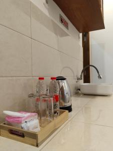 a kitchen counter with bottles of water and a tea kettle at KENEWAE LIVING in Wonosari