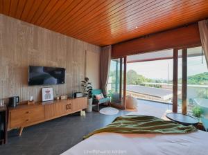 ラン島にあるPhuzita Kohlarn-ภูศิตา เกาะล้านのベッドルーム1室(ベッド1台、壁にテレビ付)