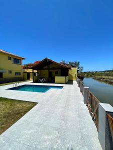uma casa com piscina ao lado de um rio em Ótima Casa com Piscina, Sauna e Churrasqueira em Cabo Frio