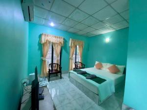 1 dormitorio con paredes azules, 1 cama y TV en Thungtako Resort en Ban Samnak Pling