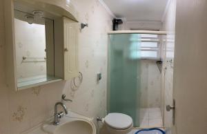 y baño con ducha, lavabo y aseo. en Apartamento Guarujá 5min a pé da Praia da Enseada, en Guarujá