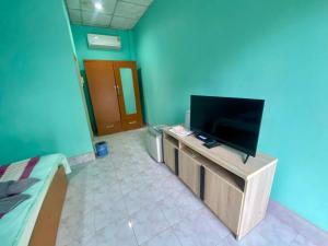 a living room with a flat screen tv on a stand at Thungtako Resort in Ban Samnak Pling