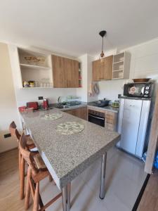 a kitchen with a table with a counter top at Lindo Departamento en Costanera de Villarrica in Villarrica