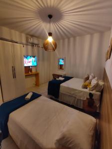 a hotel room with two beds and a tv at Ap8 atrás da Passarela do caranguejo- Orla de Atalaia in Aracaju