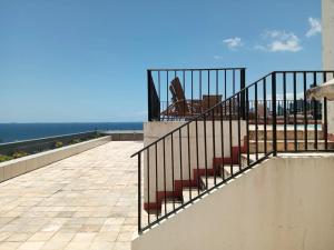 a railing on a balcony with the ocean in the background at Studio charmoso na praia de Ondina perto de tudo in Salvador