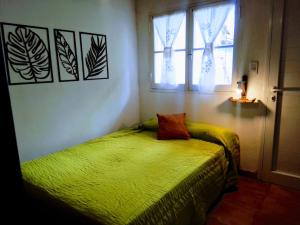 ein Schlafzimmer mit einem grünen Bett und einem Fenster in der Unterkunft Dpto tipo cabaña a 3 cuadras del mar in Mar del Plata