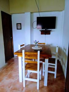 einen Esstisch mit Stühlen und einen TV an der Wand in der Unterkunft Dpto tipo cabaña a 3 cuadras del mar in Mar del Plata
