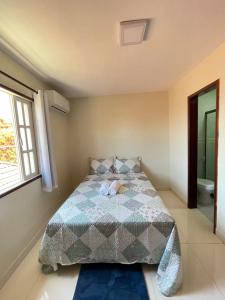 um quarto com uma cama e uma janela em Ótima Casa com Piscina, Sauna e Churrasqueira em Cabo Frio