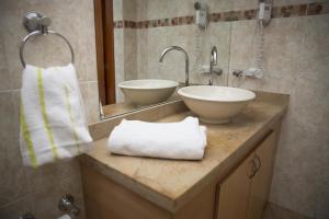 a bathroom with two sinks and two towels on a counter at Hostal Bogotá Real in Bogotá