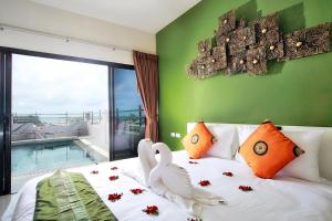 Un dormitorio con una cama con dos cisnes. en Gu Hotel Patong, en Patong Beach