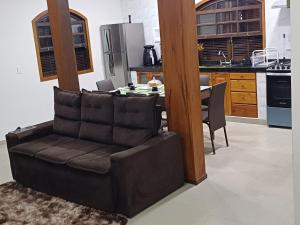 einen braunen Ledersessel in einer Küche mit einem Tisch in der Unterkunft Residência Pádua in Paraty