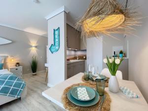 une cuisine et un salon avec une table avec des assiettes dessus dans l'établissement Germania-22, à Sankt Peter-Ording 19 autres photos