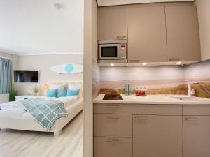 une petite chambre avec un lit et une cuisine dans l'établissement Germania-22, à Sankt Peter-Ording