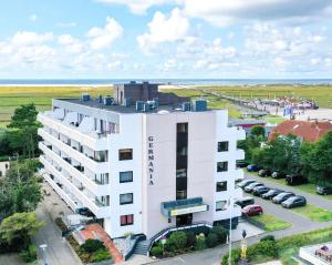 une vue aérienne d'un bâtiment blanc avec un parking dans l'établissement Germania-22, à Sankt Peter-Ording
