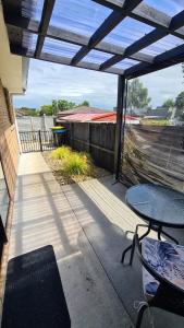 un patio con una mesa, una mesa y una valla en Bonnie Doone en Te Awamutu